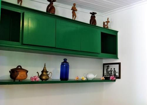 a shelf with green cabinets and vases on it at Comfortable Studio with Sea View in Foulpointe - 30 m² in Foulpointe