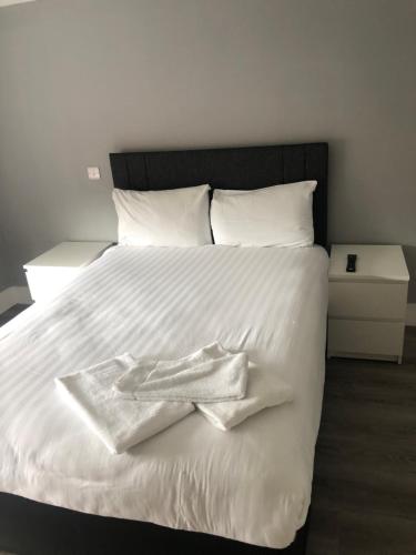 Una cama blanca con dos toallas encima. en Bay View Holiday Home Galway en Galway