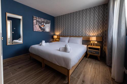 a bedroom with a large white bed with blue walls at Ta' Tereza In Manwel Dimech in Sliema