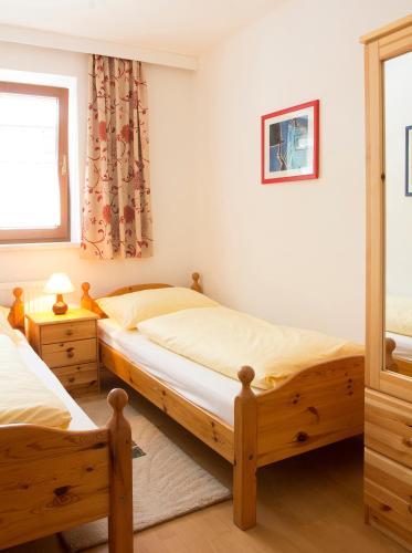 a bedroom with two twin beds and a window at Antares am See in Maurach