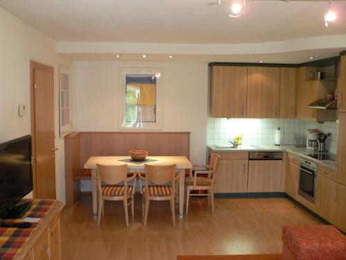 a kitchen with a table and chairs in a room at Antares am See in Maurach