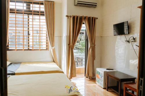 - une petite chambre avec un lit et une fenêtre dans l'établissement SH Hotel, à Hue