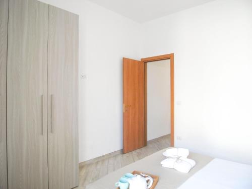 トッレ・デル・オルソにあるAppartamenti Via Corfù - Le vie di Omeroの白い壁のベッドルーム1室、鏡付きのベッド1台が備わります。