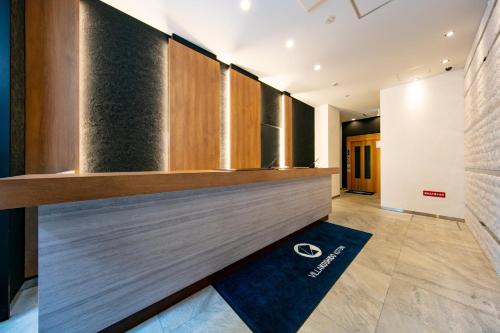 a kitchen with wooden cabinets and a blue rug at VILLA KOSHIDO kotoni in Sapporo