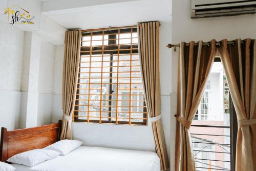 a bedroom with a bed and a window at SH Hotel in Hue
