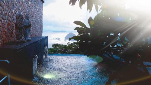a view of the ocean from a house with a water fountain at Bayview Gardens Hotel in Labuan Bajo