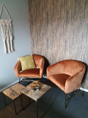 two chairs and a coffee table in a room at Bed and Breakfast Kik en Bun in Katwijk aan Zee