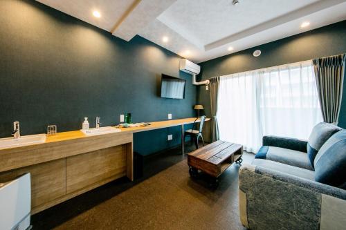 a living room with a couch and a sink and a table at VILLA KOSHIDO kotoni in Sapporo