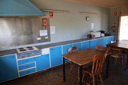 a kitchen with blue cabinets and a wooden table at Capri Motel in Balranald