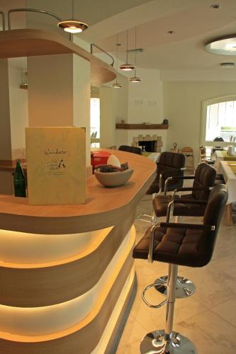 a salon with a bar with chairs and a counter at Landhotel Kristall in Bad Marienberg