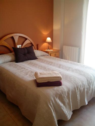a bedroom with a white bed with two towels on it at Casa María Jesús in Pórtugos
