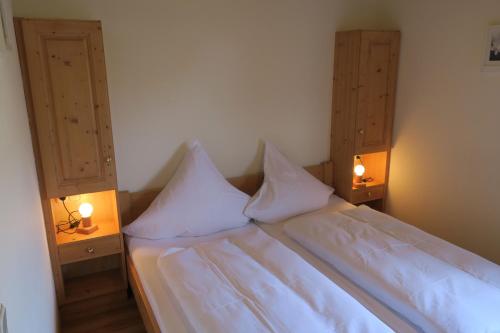 a bed with white sheets and pillows in a room at Gasthof Tiroler Hof in Bad Feilnbach