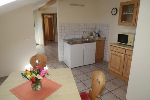 a kitchen with a table with a vase of flowers on it at Gasthof Tiroler Hof in Bad Feilnbach