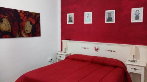 a red bedroom with a bed with a red blanket at Sa Rosa e su Trapperi in Oschiri