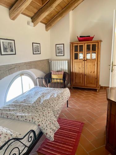 a bedroom with a bed and a chair in a room at La Famulenta 17 in Grazzano Badoglio