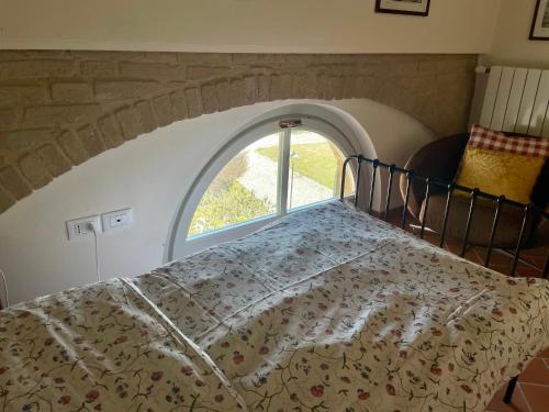 a bed in a room with an arched window at La Famulenta 17 in Grazzano Badoglio