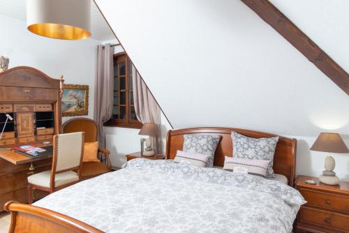 a bedroom with a bed and a desk and chair at B&B L'Eden in Aigle