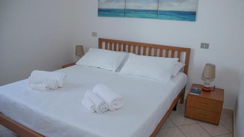 a bedroom with a white bed with towels on it at Oasi in centro - Cala Gonone in Cala Gonone