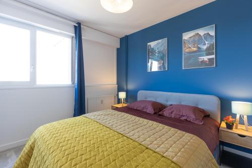 a bedroom with blue walls and a bed with purple pillows at Le petit Manhattan - Appartement privé de 45 m2 - 2 à 4 personnes - Parking privé in Metz