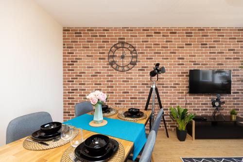 a dining room with a table and a brick wall at Le petit Manhattan - Appartement privé de 45 m2 - 2 à 4 personnes - Parking privé in Metz