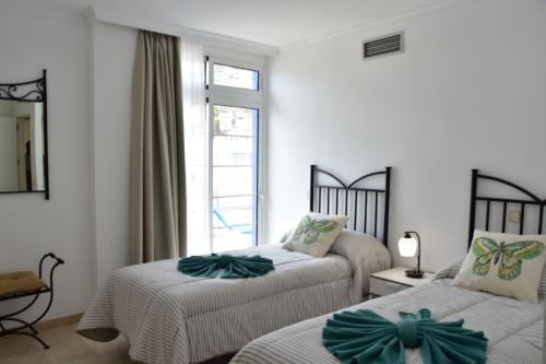 a bedroom with two beds with green bows on them at BEACH SIDE in Puerto de Mogán
