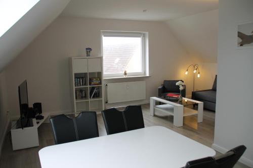 ein Wohnzimmer mit einem weißen Tisch und Stühlen in der Unterkunft Büsumer Ferien Alleestraße in Büsum