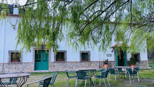 a group of tables and chairs in front of a building at Hotel de Montaña La Hortizuela in Coto Rios