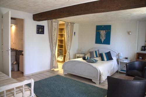 a bedroom with a bed and a chair in a room at Chambre d hote La Roussiere in Saint-Ouen-des-Toits