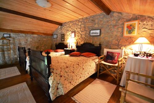 a bedroom with a bed and a stone wall at Quinta de Santa Baia in Gaifar