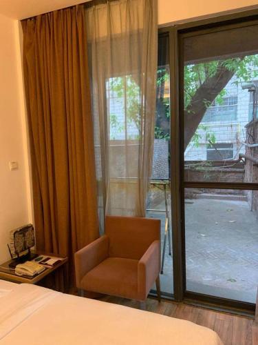 a bedroom with a bed and a chair and a window at Guangzhou Fangyuan Hotel - Free Shuttle Bus to Canton Fair Complex during 14th Oct to 3rd Nov in Guangzhou