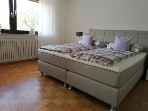 een slaapkamer met een groot bed met paarse kussens bij FeWo mit Burgblick in Kreuzwertheim