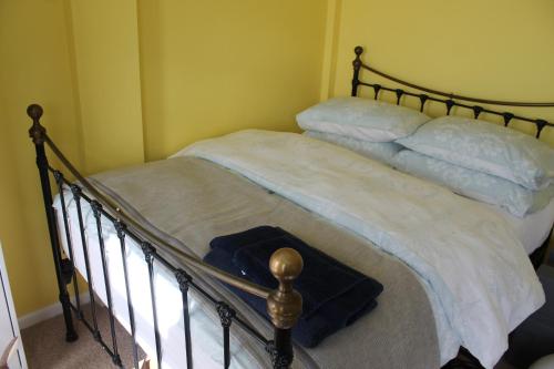 una camera da letto con letto, lenzuola e cuscini bianchi di The Garden Room Westcott a Westcott