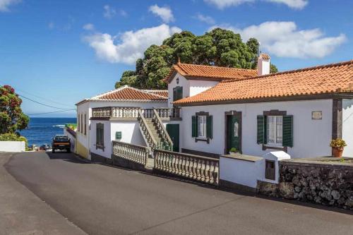 a house on the side of a road next to the ocean at Vivenda Gomes AL in Porto Martins