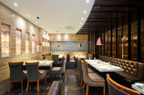a restaurant with wooden walls and tables and chairs at Hotel Golden Palace in Kolkata