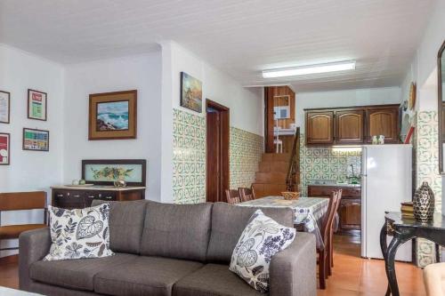 a living room with a couch and a table and a kitchen at Vivenda Gomes AL in Porto Martins