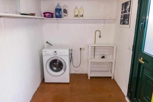 a small laundry room with a washing machine in it at Vivenda Gomes AL in Porto Martins