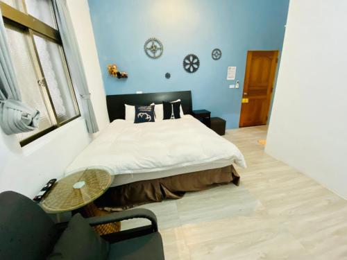 a bedroom with a bed with a table and a chair at 居家民宿-岩手二館 in Eluan