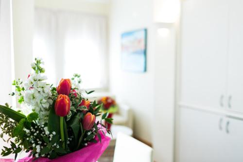 a vase of tulips and other flowers on a table at Rex Hotel Residence in Genova