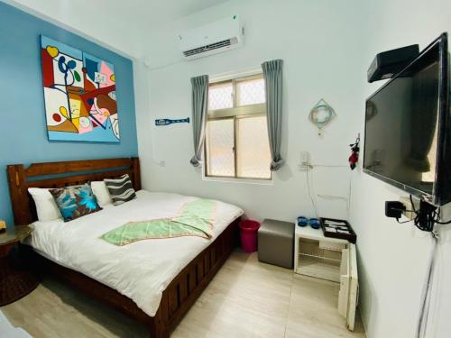 a bedroom with a bed and a flat screen tv at 居家民宿-岩手二館 in Eluan