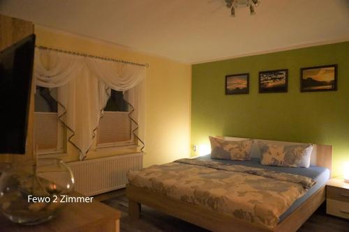 ein Schlafzimmer mit einem Bett und einem TV in der Unterkunft Ferienwohnung Füssel in Rathmannsdorf