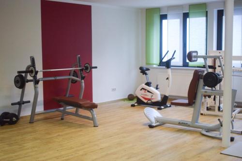 a gym with several exercise equipment in a room at Akzent Hotel Jonathan in Lippstadt