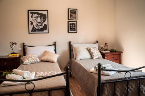 a bedroom with two beds and a picture on the wall at Il Madrigale - Agriturismo B&B in Agnone