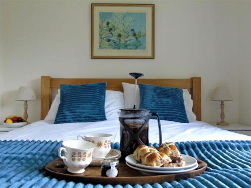 ein Tablett mit Croissants und Kaffeetassen auf dem Bett in der Unterkunft Bond's Cottage Barn in Royal Tunbridge Wells