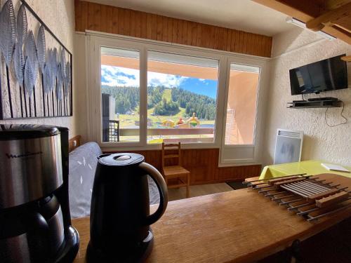 a room with a coffee maker on a table with a window at SUPER LIORAN - APPARTEMENT ENTIÈREMENT ÉQUIPÉ in Laveissière