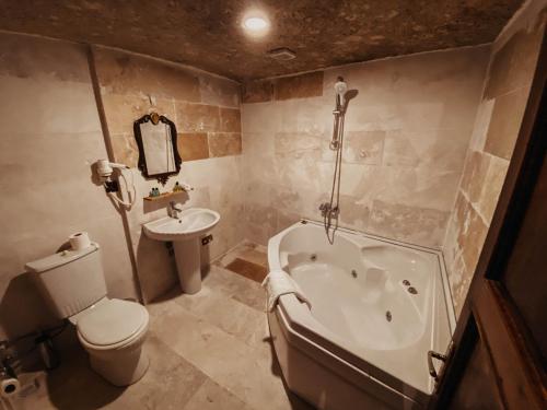 a bathroom with a tub and a toilet and a sink at Asteria Cave Hotel in Goreme