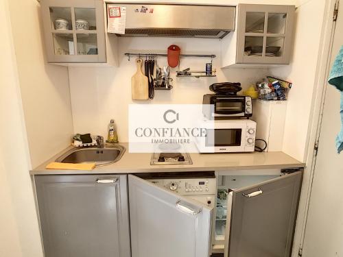 a small kitchen with a sink and a microwave at Amiral de Grasse in Nice
