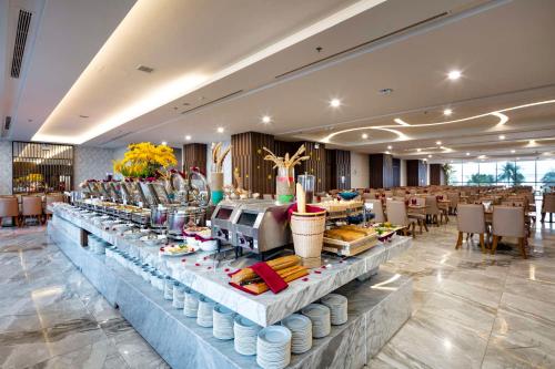 a buffet line with food on it in a restaurant at Vesna Hotel in Nha Trang