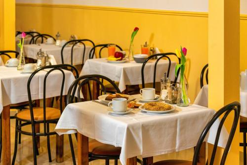 a dining room with tables and chairs with food on them at Nea Metropolis in Thessaloniki