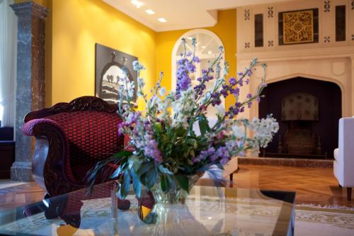 a vase of purple and white flowers on a glass table at The Ashbee Hotel in Taormina