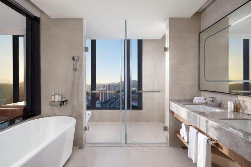 a bathroom with a tub and two sinks and a shower at Holiday Inn Chengde Park View, an IHG Hotel in Chengde